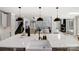 Modern kitchen with island sink, pendant lighting, and views of an open-concept living space with a fireplace at 8707 Fairview Rd, Charlotte, NC 28226