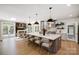 Spacious kitchen with a large island, modern pendant lighting, and an adjacent dining area with fireplace at 8707 Fairview Rd, Charlotte, NC 28226