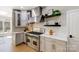 Close-up of a kitchen area featuring a stainless steel range, modern hood, and light-gray cabinets at 8707 Fairview Rd, Charlotte, NC 28226