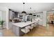 Bright, open kitchen with stainless steel appliances, gray cabinetry, and large marble island with barstool seating at 8707 Fairview Rd, Charlotte, NC 28226