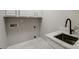 This laundry room features cabinetry, a sink, and modern faucet, making chores more convenient at 8707 Fairview Rd, Charlotte, NC 28226