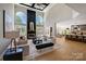 Spacious living room featuring a soaring ceiling, fireplace and an open floor plan into the kitchen at 8707 Fairview Rd, Charlotte, NC 28226