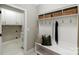 This mudroom features a bench, hooks, storage, and access to the laundry area with a sink at 8707 Fairview Rd, Charlotte, NC 28226