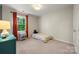 Bright bedroom with a plush carpet, a twin bed with colorful bedding, and a large window at 9002 Maple Hill Ct, Huntersville, NC 28078