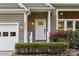 Charming front porch with white trim, a sidelight, and a manicured garden with vibrant roses at 9002 Maple Hill Ct, Huntersville, NC 28078