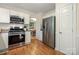 Kitchen featuring stainless appliances, white cabinets, and hardwood floors at 9002 Maple Hill Ct, Huntersville, NC 28078
