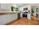 Kitchen featuring stainless appliances, granite counters, white cabinets, and hardwood floors at 9002 Maple Hill Ct, Huntersville, NC 28078