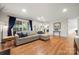 Open living room with hardwood floors, large windows, and a view of the kitchen at 9002 Maple Hill Ct, Huntersville, NC 28078