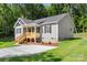 View of the front exterior, lawn, and driveway of this gray home with a charming covered porch at 951 Hardin Dr, Shelby, NC 28150