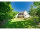 Expansive backyard with lush greenery, a wooden fence, and a spacious deck for outdoor enjoyment at 9700 Stewart Spring Ln, Charlotte, NC 28216