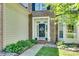 Close-up of the front door featuring detailed molding, a decorative wreath, and professional landscaping at 9700 Stewart Spring Ln, Charlotte, NC 28216