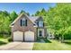 Charming brick two-story home featuring a well-manicured lawn, two-car garage, and mature trees at 9700 Stewart Spring Ln, Charlotte, NC 28216