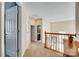 A hallway with carpet, white doors, and a view of a bathroom and staircase at 9700 Stewart Spring Ln, Charlotte, NC 28216