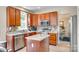 Well-lit kitchen with stainless steel appliances, granite countertops, and wooden cabinetry with breakfast bar at 9700 Stewart Spring Ln, Charlotte, NC 28216