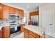 Kitchen featuring stainless steel appliances, granite countertops, wood cabinets, and a kitchen island with storage at 9700 Stewart Spring Ln, Charlotte, NC 28216