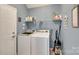 Laundry room with a washer, dryer, and storage shelves, all in a well-organized space at 9700 Stewart Spring Ln, Charlotte, NC 28216