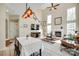 Living room and staircase featuring a fireplace, high ceilings, and an open floor plan with the dining room and kitchen at 9700 Stewart Spring Ln, Charlotte, NC 28216