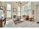 Bright living room featuring a fireplace, large windows, and natural light with hardwood floors and comfortable seating at 9700 Stewart Spring Ln, Charlotte, NC 28216