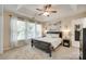 Bright main bedroom with tray ceiling, neutral carpet, and coastal-themed decor at 9700 Stewart Spring Ln, Charlotte, NC 28216