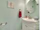 A stylish powder room with modern fixtures, a round mirror, and light teal walls at 9700 Stewart Spring Ln, Charlotte, NC 28216