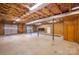 Unfinished basement with exposed beams, shelving, and garage doors, offering potential for customization at 993 Jackson Rd, Fort Lawn, SC 29714