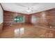 Spacious bedroom showcasing hardwood floors, wood-paneled walls, and a large window overlooking the outdoor scenery at 993 Jackson Rd, Fort Lawn, SC 29714