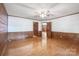 Spacious bedroom featuring hardwood floors, wood-paneled walls, with a doorway that connects the rooms at 993 Jackson Rd, Fort Lawn, SC 29714