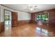Bright bedroom showcasing hardwood floors, wood-paneled walls, and a large doorway that connects the rooms at 993 Jackson Rd, Fort Lawn, SC 29714