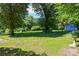 Spacious backyard with lush green lawn and mature trees, perfect for outdoor activities at 1004 Midwood Dr, Monroe, NC 28112