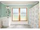 Well-lit bathroom with shower-tub combination, patterned shower curtain, and a decorative mirror at 1004 Midwood Dr, Monroe, NC 28112