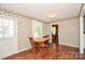 Cozy dining room with wood floors, a wooden table with chairs, and bright, floral wallpaper at 1004 Midwood Dr, Monroe, NC 28112