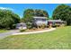 Charming two-story home with a well-manicured front yard, mature trees, and a two-car garage at 1004 Midwood Dr, Monroe, NC 28112