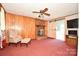Cozy living room with a brick fireplace, wood paneling, ceiling fan and sliding barn door at 1004 Midwood Dr, Monroe, NC 28112