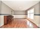 Spacious living room featuring hardwood flooring, a piano, and bright natural light at 1004 Midwood Dr, Monroe, NC 28112