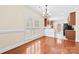 Dining area with hardwood floors, plantation shutters, and a view into the kitchen with neutral color palette at 1161 Stuarts Landing Dr, Cramerton, NC 28032