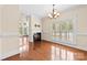 Open living room features a fireplace, hardwood flooring, and plantation shutters and chandelier at 1161 Stuarts Landing Dr, Cramerton, NC 28032