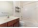 Bathroom with vanity, toilet and shower-tub combo with white tiled walls and chrome fixtures at 11707 Ridgeway Park Dr, Charlotte, NC 28277