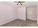 Bedroom with gray flooring, pale purple walls, door and ceiling fan at 11707 Ridgeway Park Dr, Charlotte, NC 28277