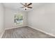 Bright bedroom featuring a ceiling fan, a large window, and modern wood-look floors at 11707 Ridgeway Park Dr, Charlotte, NC 28277