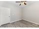 Bedroom featuring modern grey floors, light grey walls, a ceiling fan, and a door at 11707 Ridgeway Park Dr, Charlotte, NC 28277