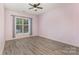 Bedroom with gray flooring, pale purple walls, window, curtains and ceiling fan at 11707 Ridgeway Park Dr, Charlotte, NC 28277