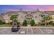 Inviting exterior of a two-story condo building with well-maintained landscaping and ample parking at dusk at 11707 Ridgeway Park Dr, Charlotte, NC 28277