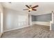 Light-filled living room with ceiling fan and grey vinyl plank flooring throughout at 11707 Ridgeway Park Dr, Charlotte, NC 28277