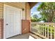 Inviting porch with a view of green trees, a white door, and a brick support pillar at 11707 Ridgeway Park Dr, Charlotte, NC 28277