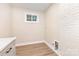 The laundry room is painted with a neutral color and includes updated, light-colored cabinetry at 1208 Fordham Rd, Charlotte, NC 28208