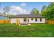 Backyard view showcasing a white home, green lawn, and outdoor seating area at 1212 Mason Way, Mount Holly, NC 28120