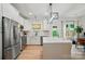 Bright kitchen with a waterfall island, stainless steel appliances, and a view to the backyard at 1212 Mason Way, Mount Holly, NC 28120