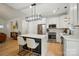 Bright kitchen features a waterfall island with seating, stainless steel appliances, and an open concept design at 1212 Mason Way, Mount Holly, NC 28120