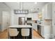 Bright kitchen features a waterfall island with seating, stainless steel appliances, and a modern light fixture at 1212 Mason Way, Mount Holly, NC 28120