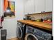Functional laundry room with butcher block countertop and overhead storage cabinets at 1212 Mason Way, Mount Holly, NC 28120